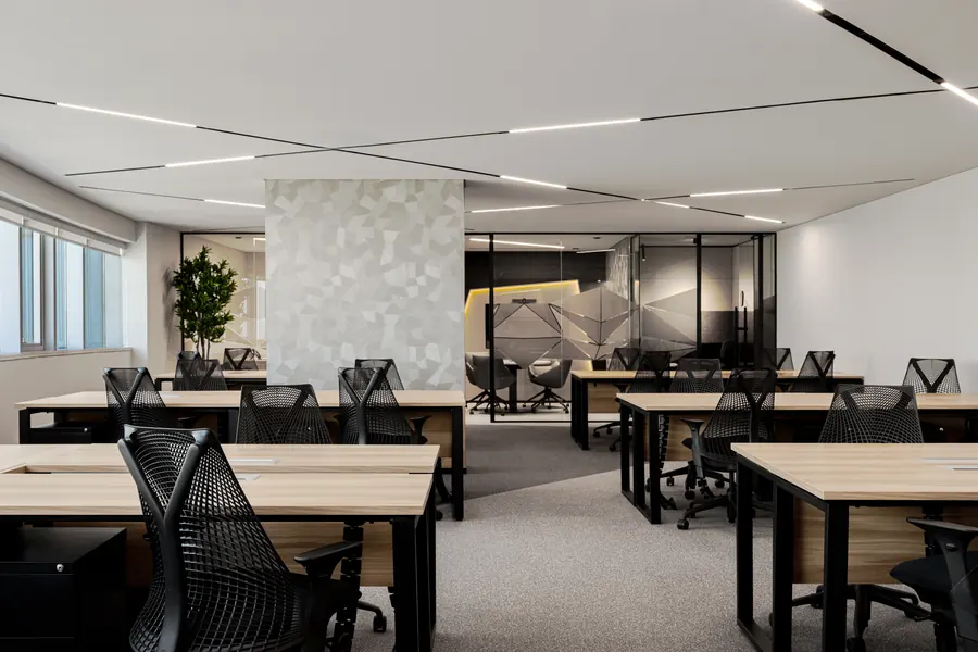 Open-plan executive suite with team workstations and a glass meeting room